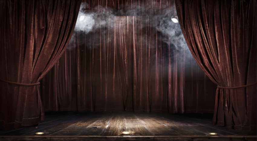 entre brumas, se ve un escenario con telones de terciopelo, apenas iluminado... la función está por comenzar