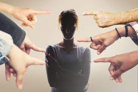 muchos dedos apuntan acusadores a la silueta de una mujer con brazos cruzados