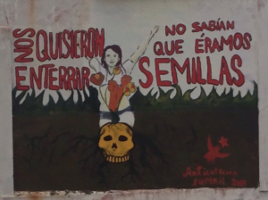 un mural en la calle, tiene enterrado un cráneo, y de él nace una mujer. Arriba dice: nos quisieron enterrar pero no sabían que éramos semillas