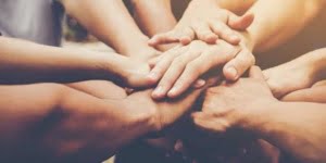 muchas manos están una encima de la otra como cuando vas a echar una porra